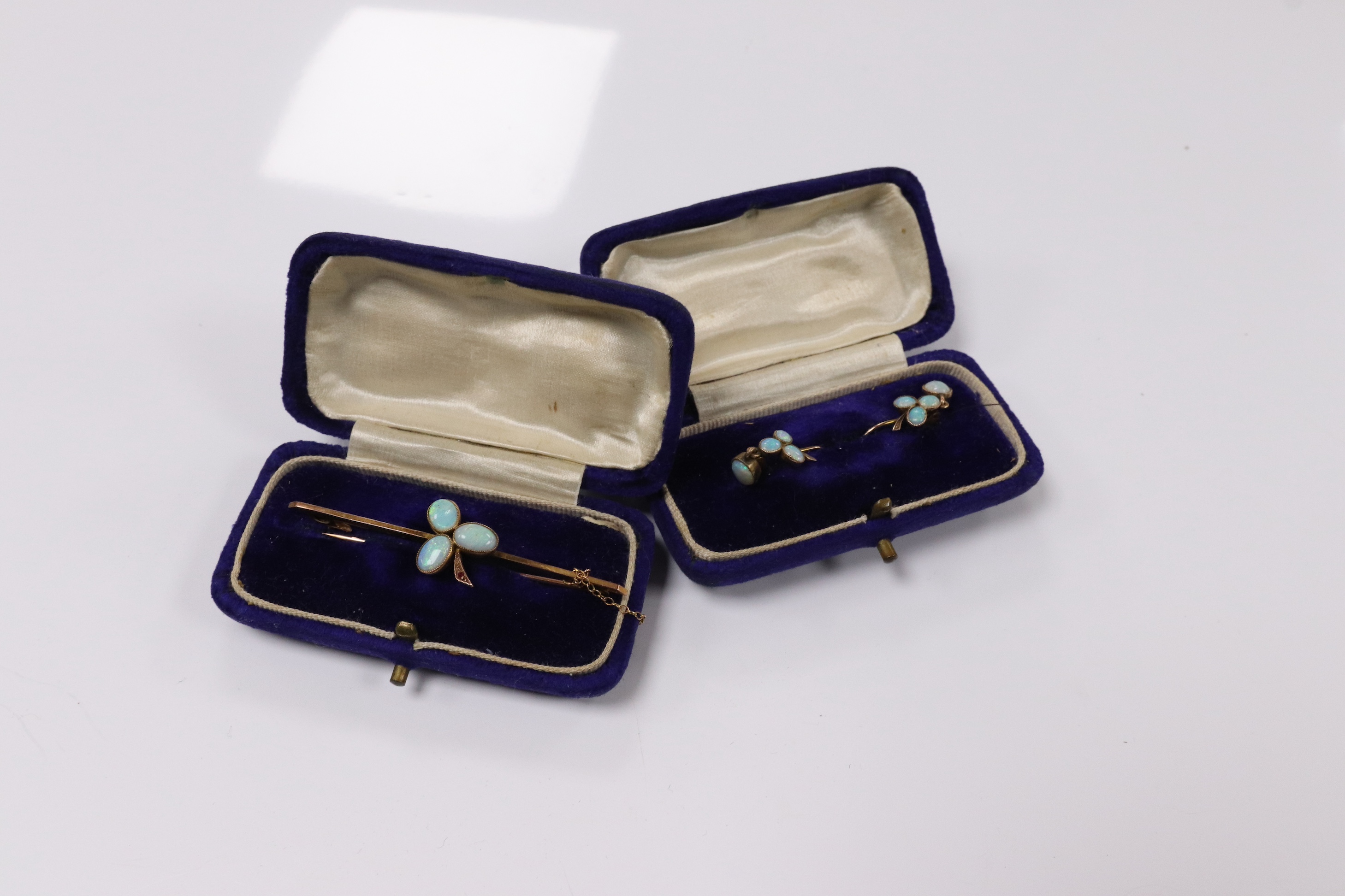 A 9ct and three stone white opal and single stone ruby set bar brooch, 58mm, together with a pair of yellow metal and opal cluster set earrings. Condition - fair